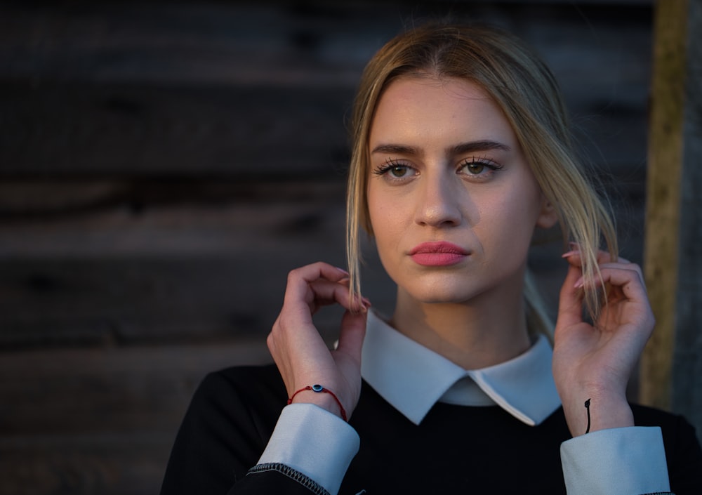 a woman with blonde hair wearing a black and white shirt