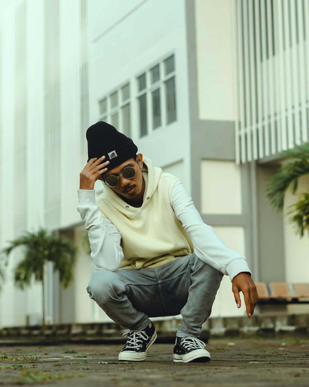 a man kneeling on the ground with a hat on