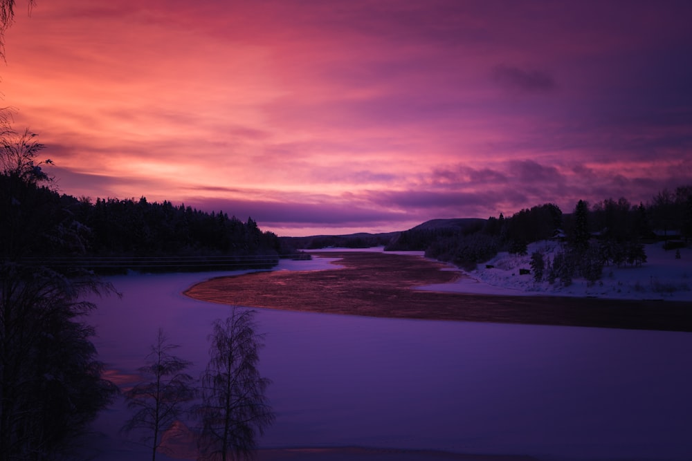 Un coucher de soleil violet et rouge sur une rivière