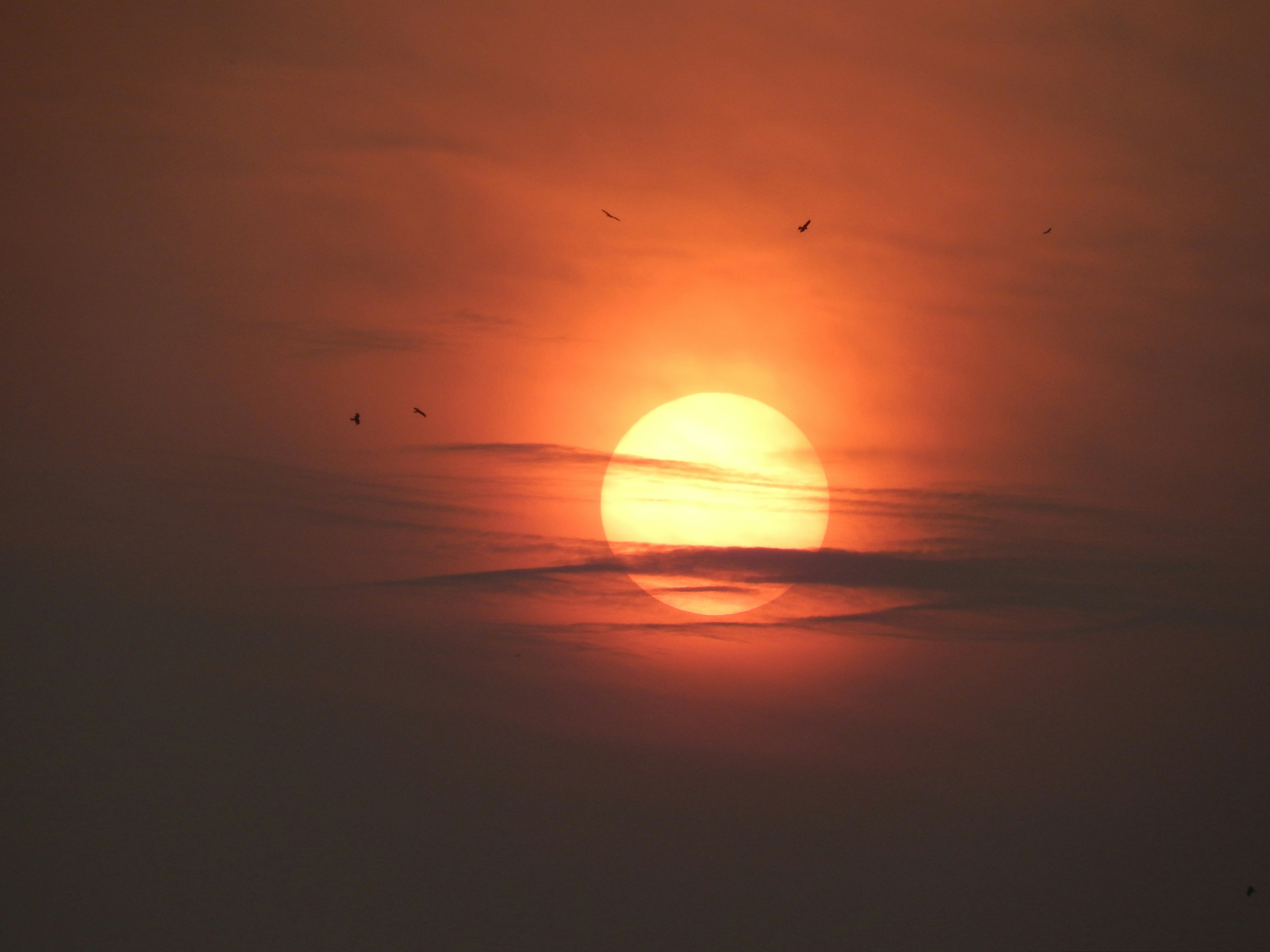 the sun is setting in the sky over the ocean