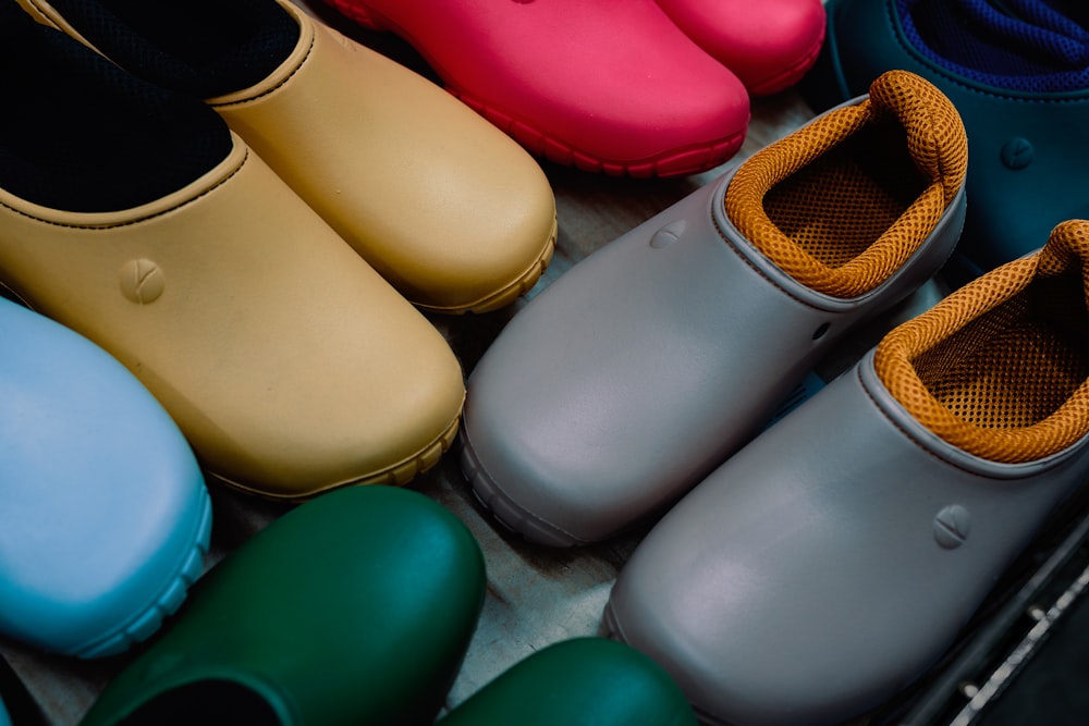 um grupo de sapatos coloridos sentados em cima de um chão