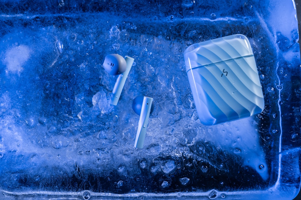 a couple of toothbrushes laying on top of ice