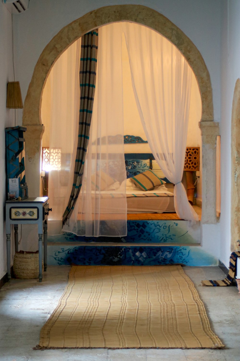 a bedroom with a canopy bed and a rug on the floor