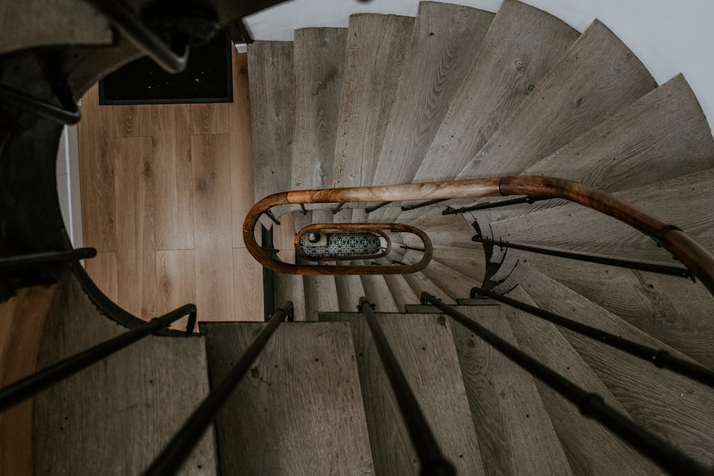a wooden spiral staircase with a metal handrail