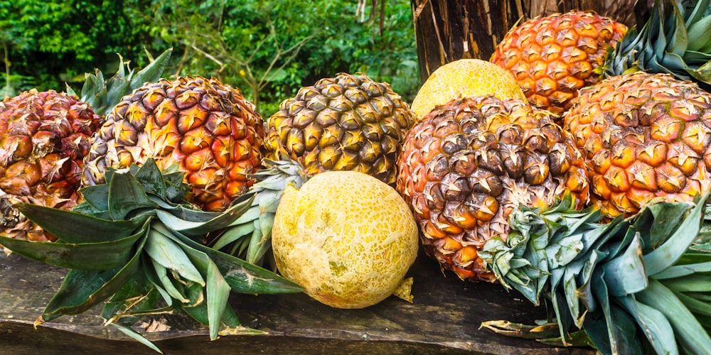 a pile of pineapples sitting on top of a wooden table