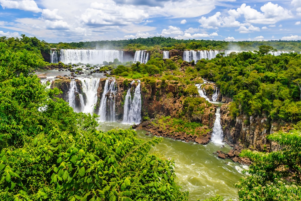 a large waterfall surrounded by lush green trees