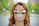 Smiling woman enjoying gum outdoors on a sunny day
