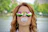 Smiling woman enjoying gum outdoors on a sunny day