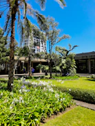 Lush landscaped garden with trees and flowers surrounding a modern building.