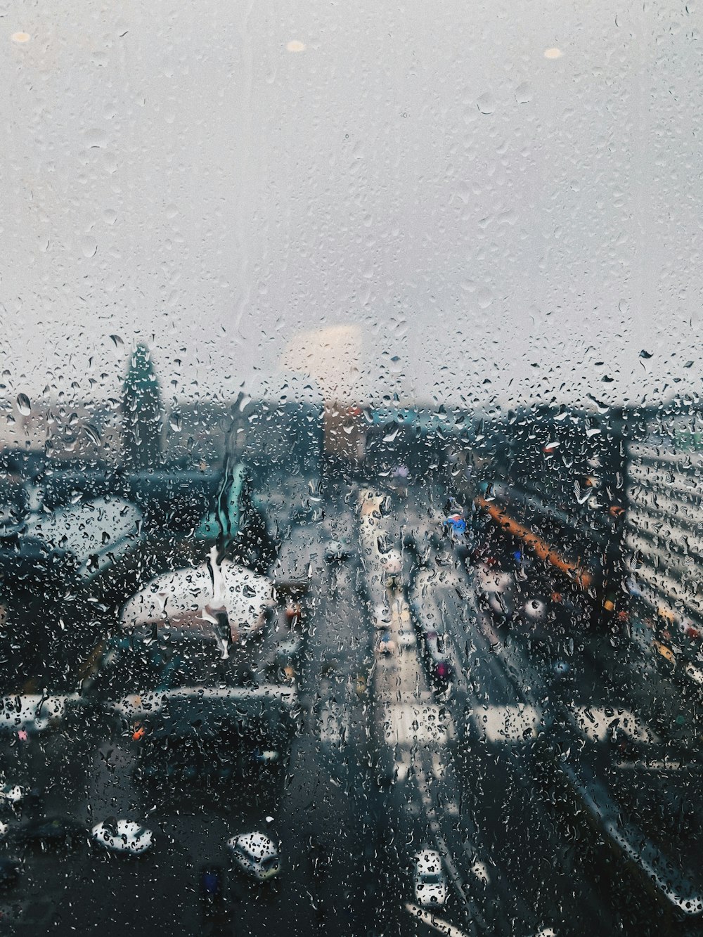 Una vista de una ciudad a través de una ventana cubierta de lluvia