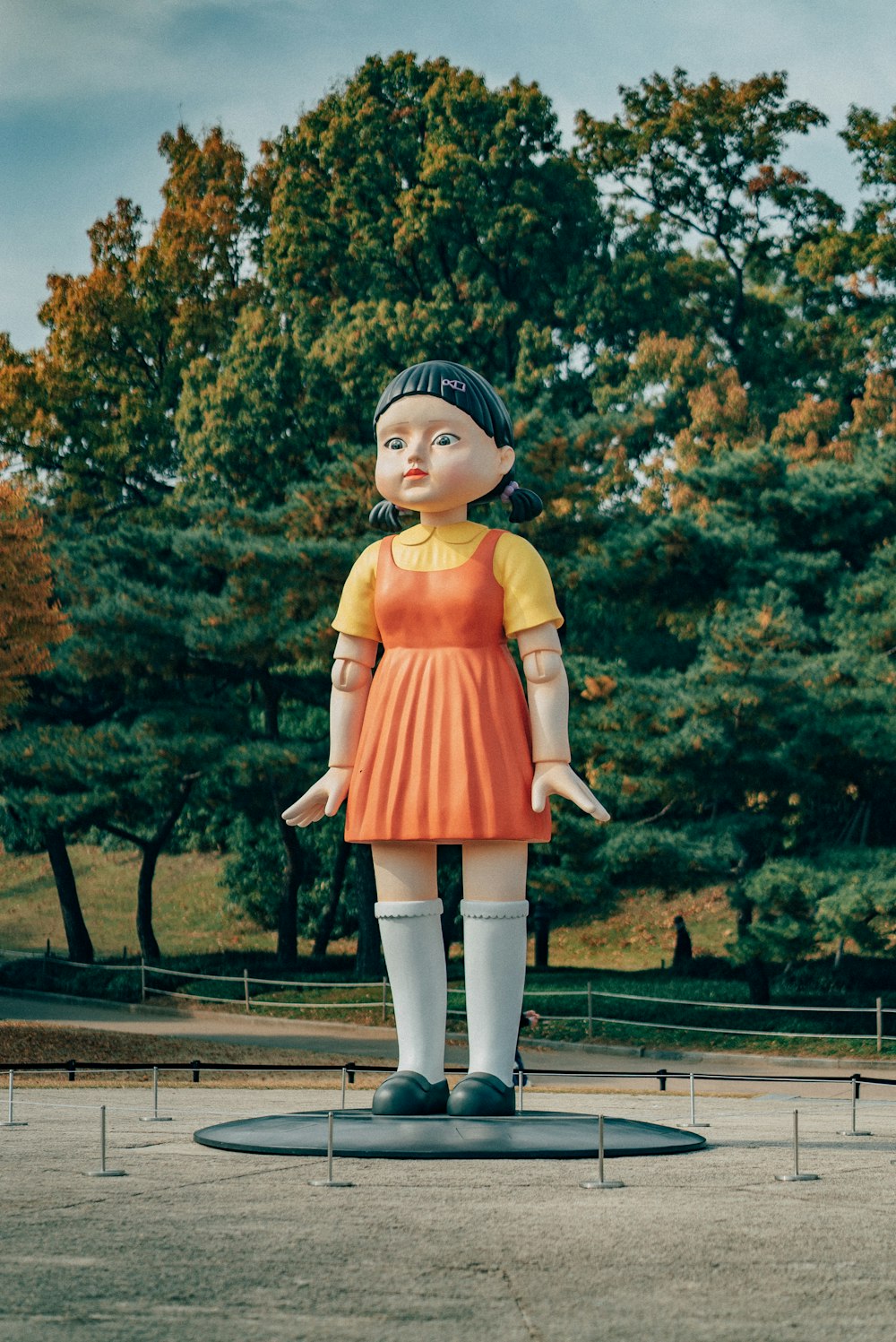 Eine Statue eines Mädchens in einem orangefarbenen Kleid