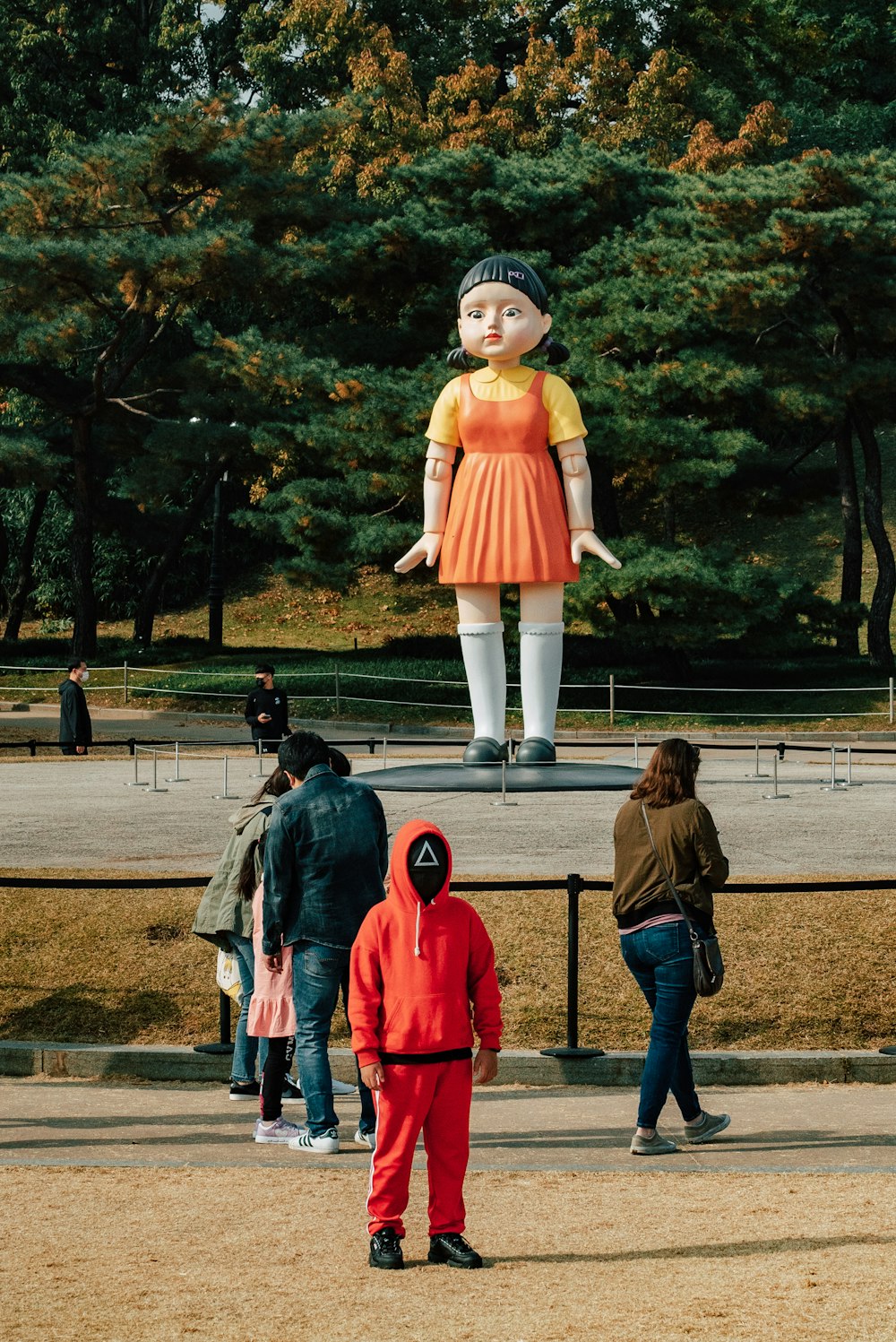 eine große Statue einer Frau in einem orangefarbenen Kleid