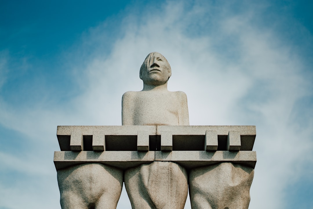 a statue of a man sitting on top of a bench,