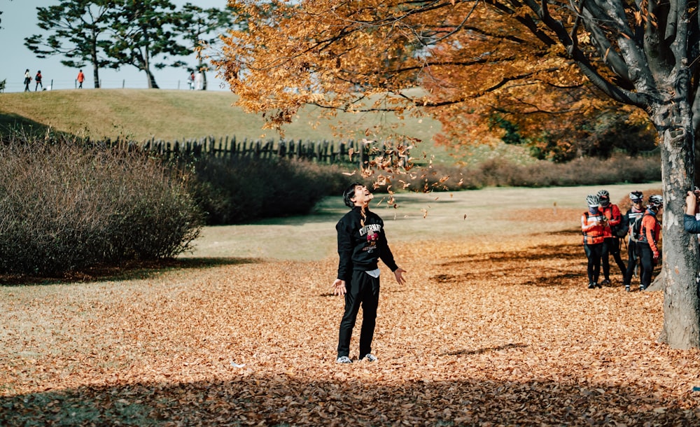 a man standing under a tree in a park