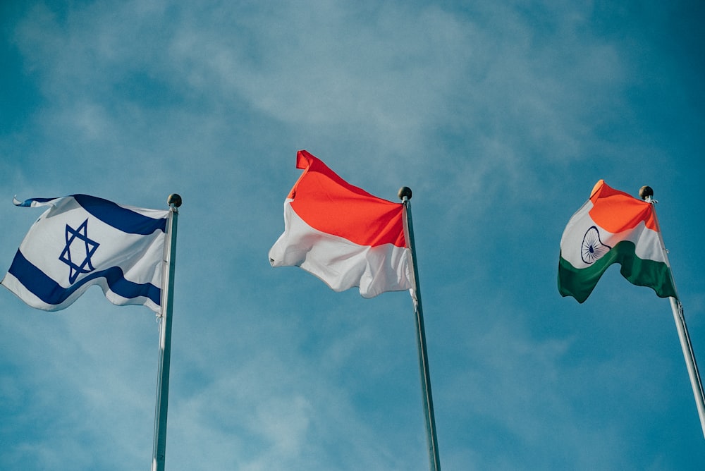 a group of three flags flying in the air