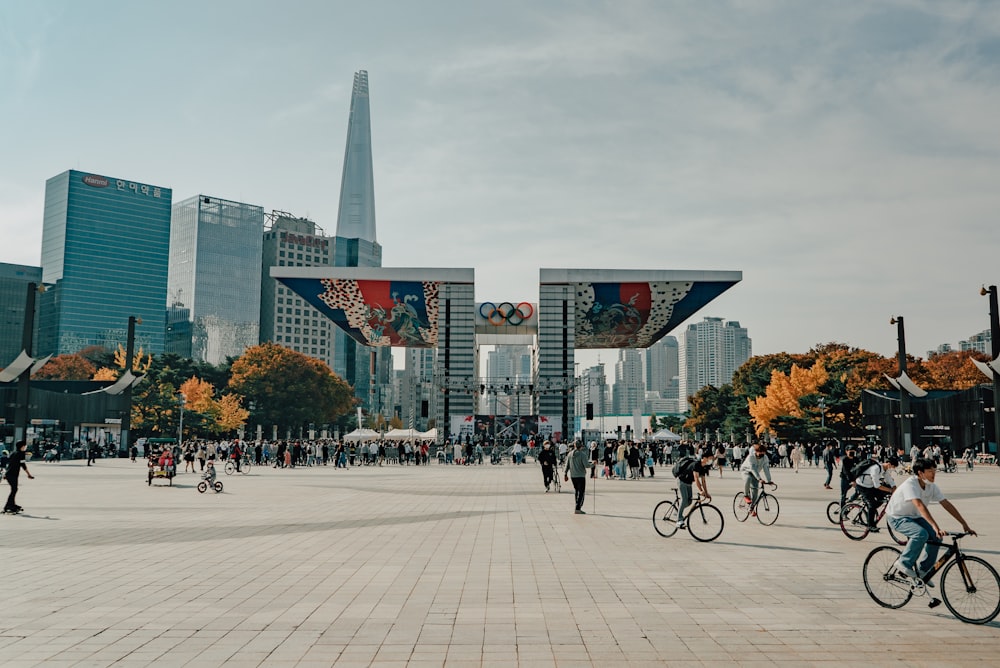 a group of people riding bikes in a city square