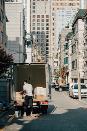 a man unloading boxes from the back of a moving truck