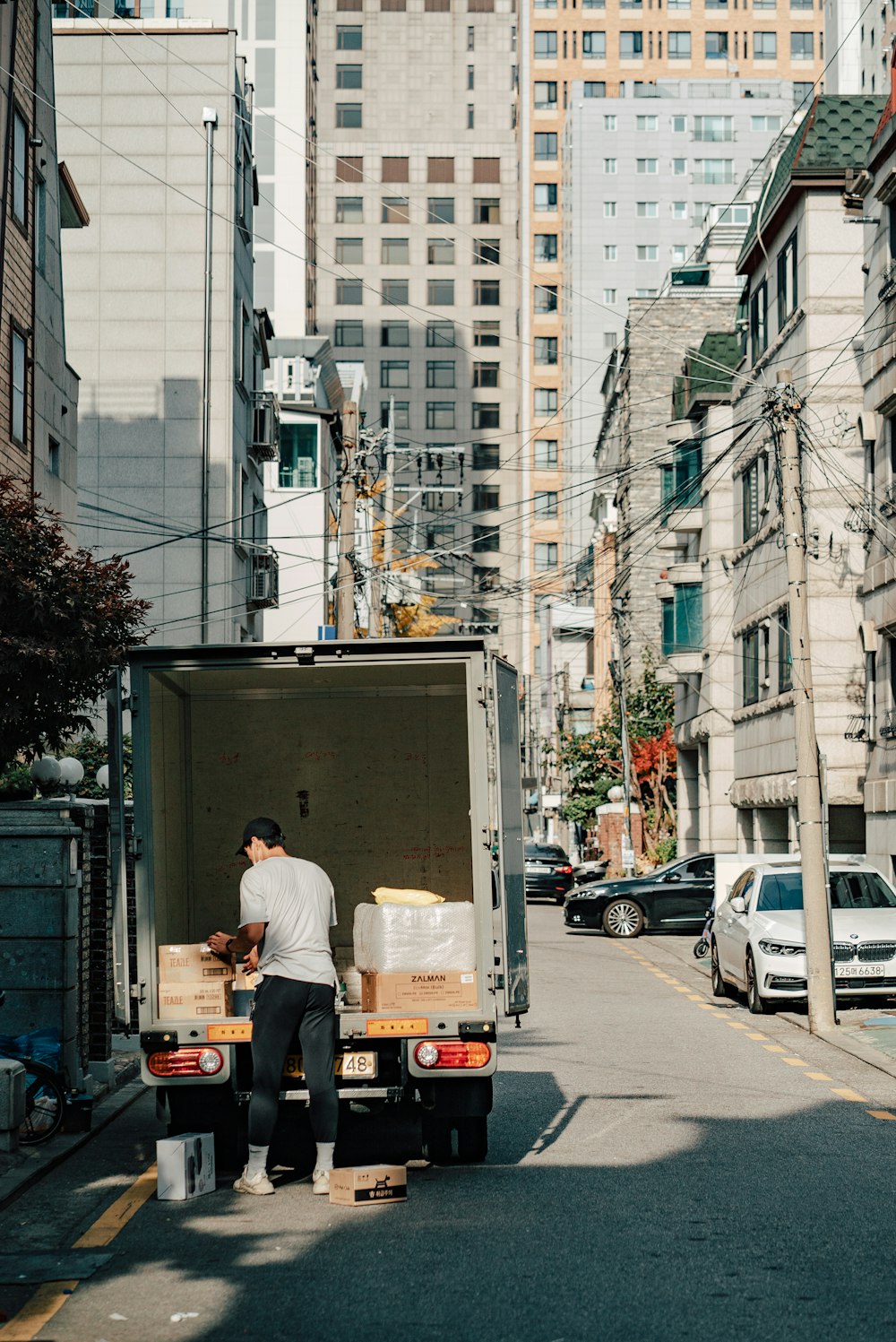 um homem descarregando caixas da parte traseira de um caminhão em movimento