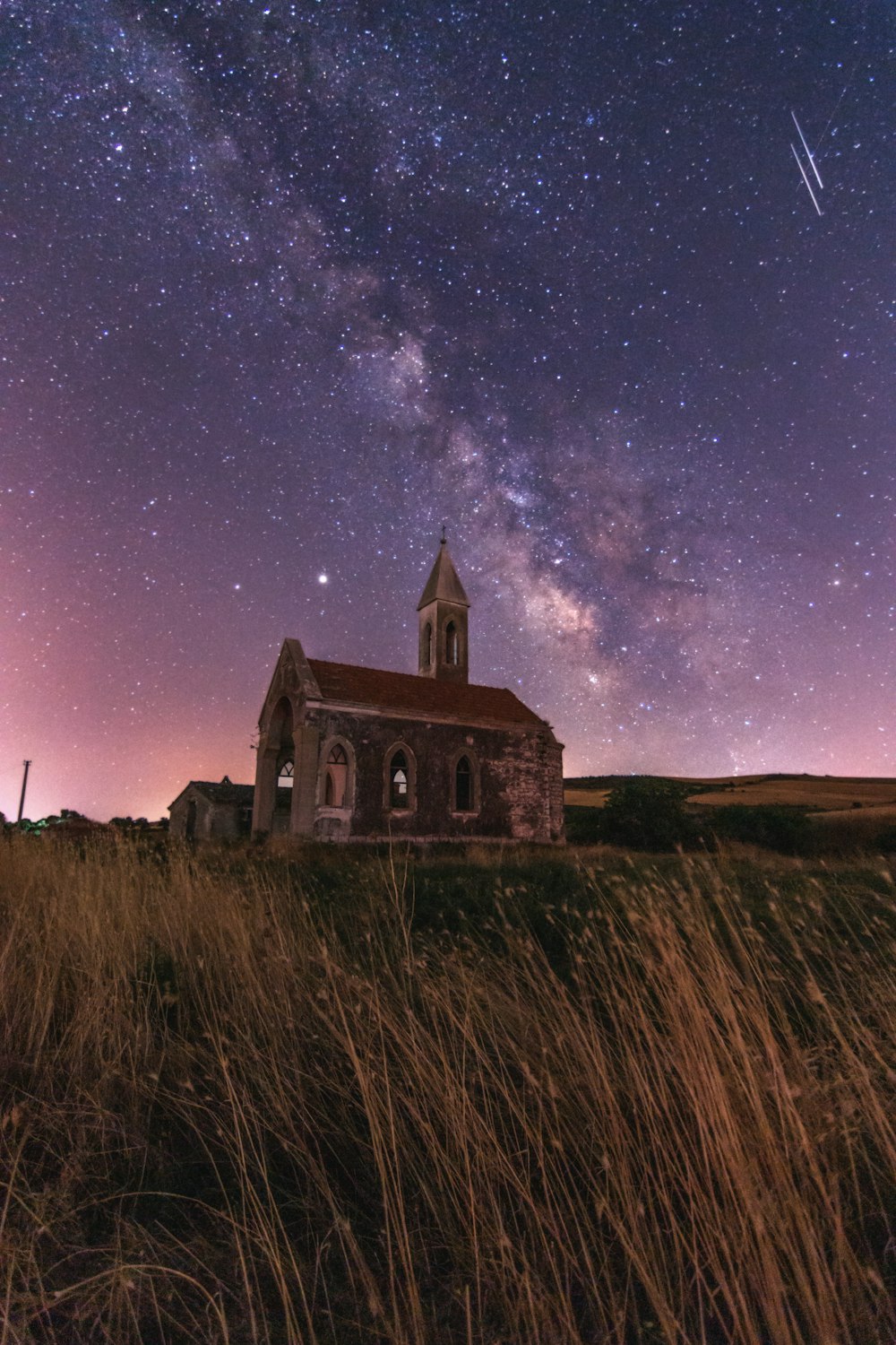 a church with a sky full of stars in the background