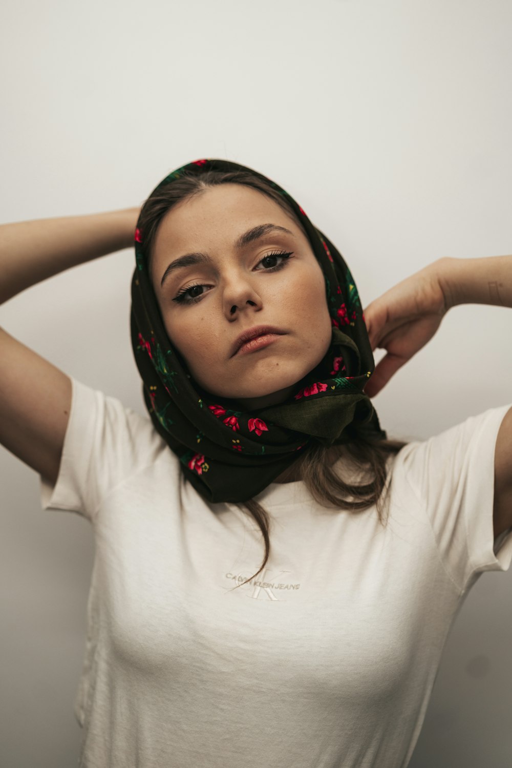 a woman wearing a white shirt and a green scarf