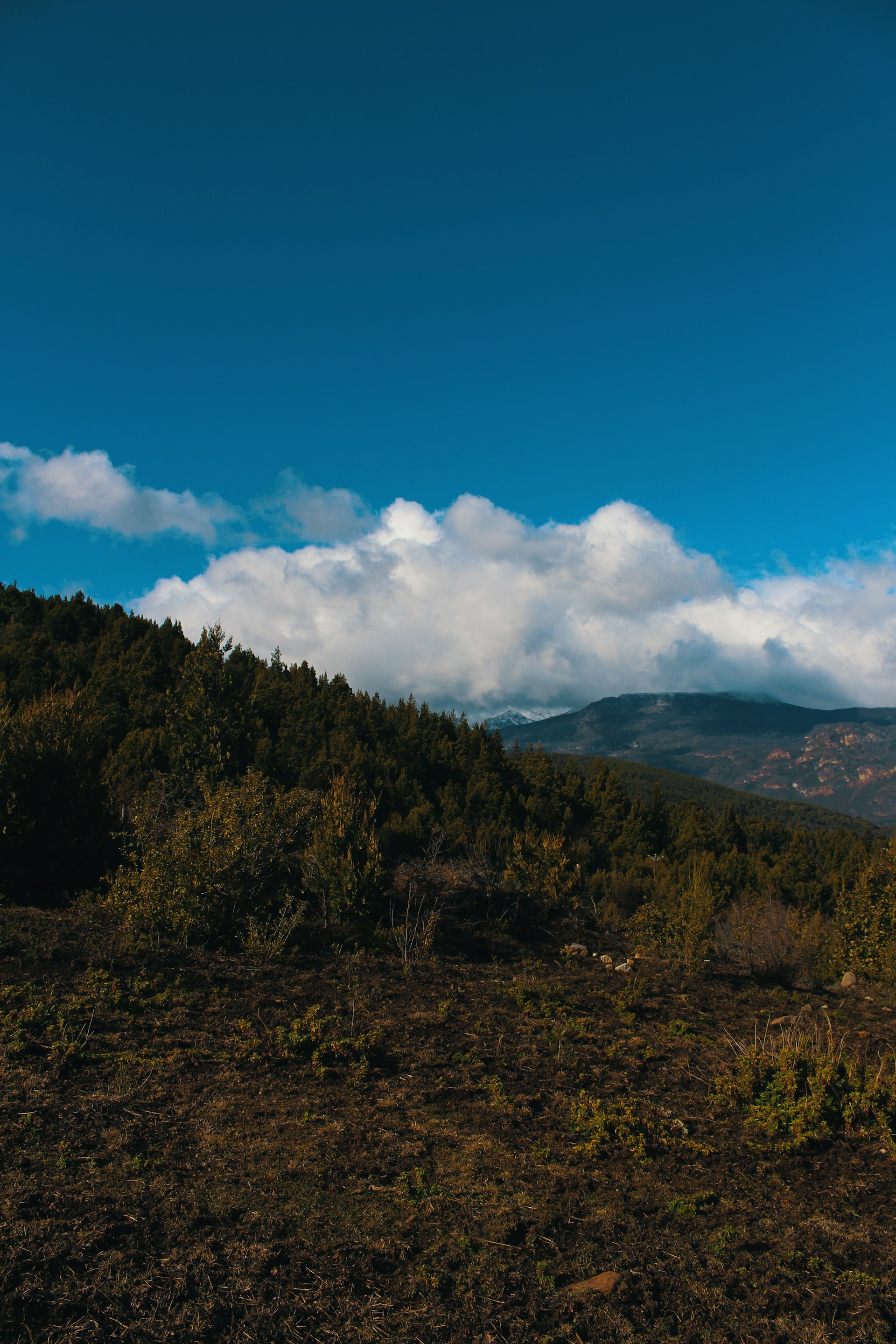 a view of a mountain with clouds in the sky