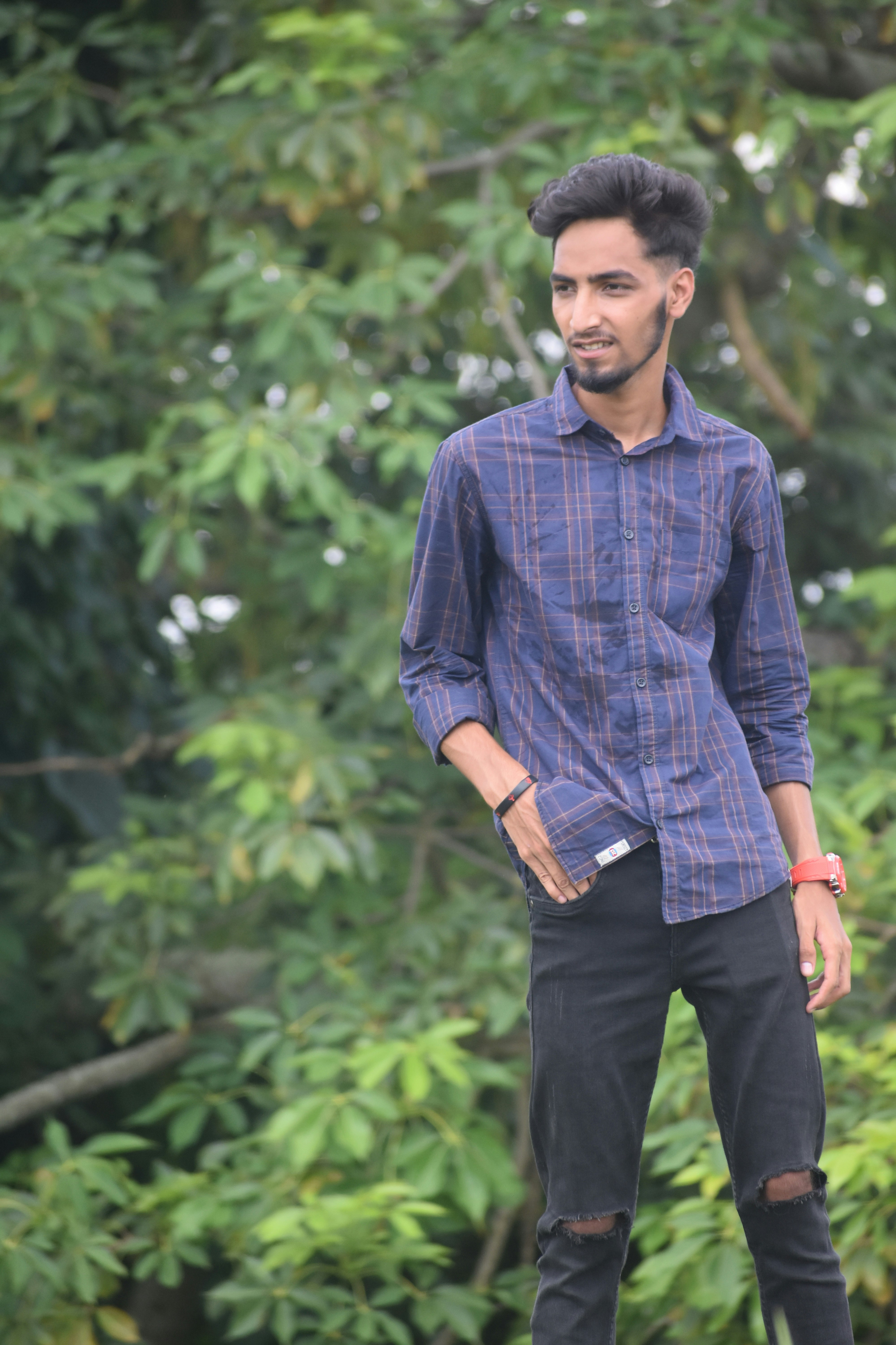 a man standing on a skateboard in front of trees