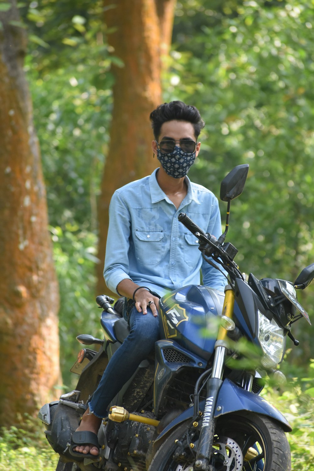 a man wearing a mask sitting on a motorcycle
