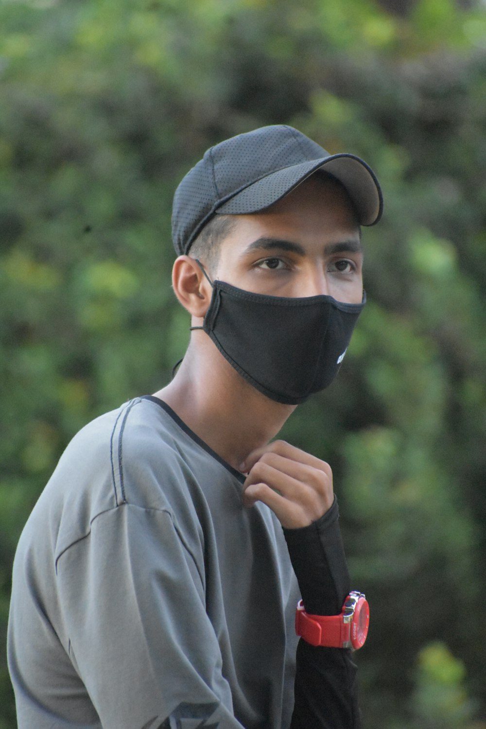 a man wearing a face mask and a baseball cap