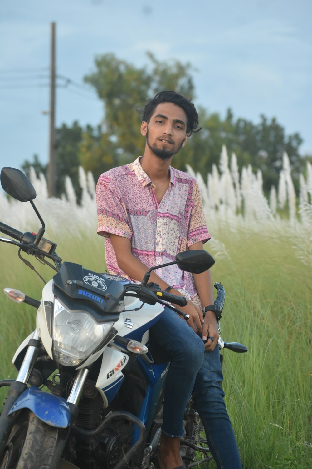 a man sitting on a motorcycle in a field