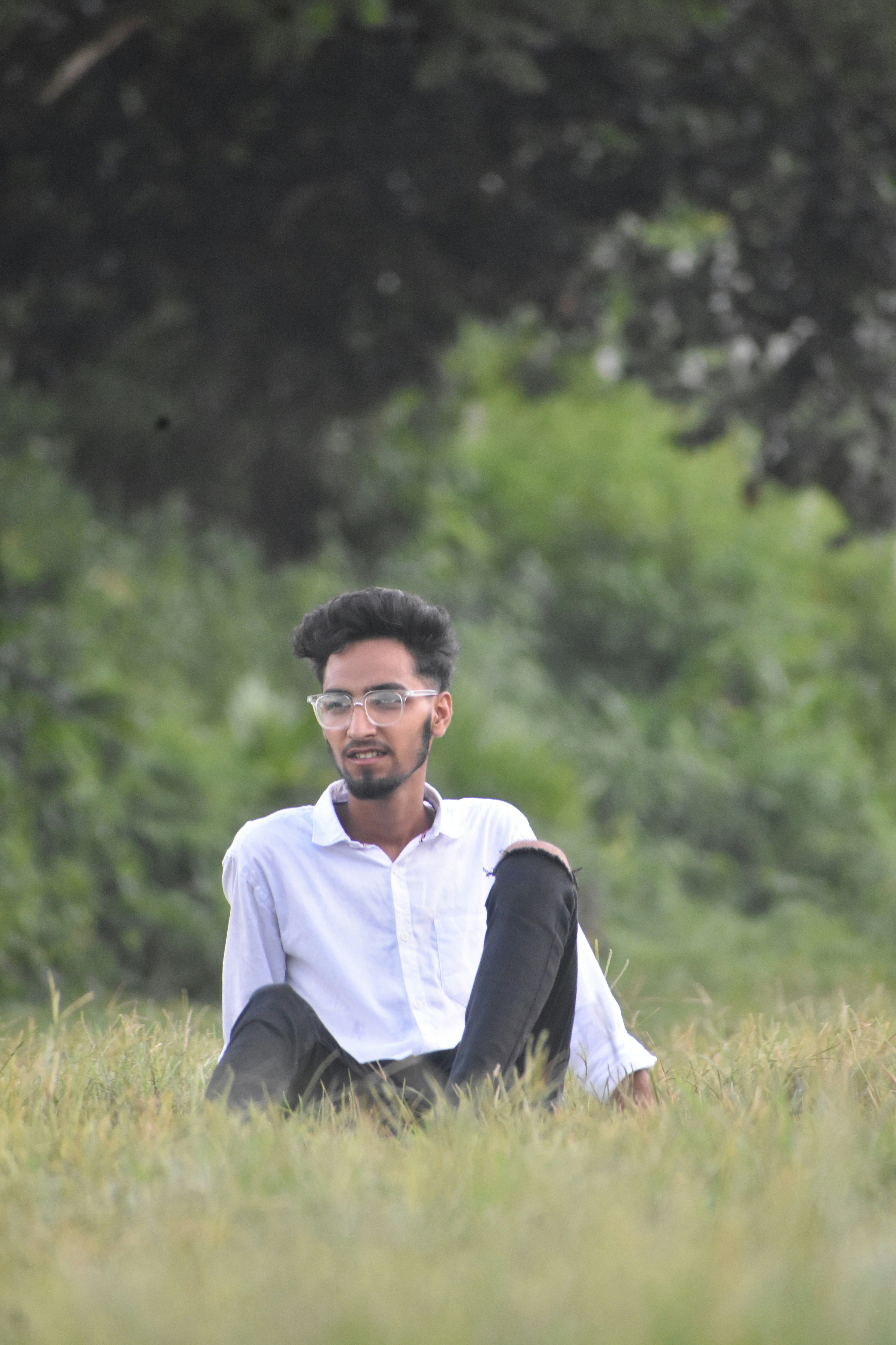 a man sitting in a field of tall grass