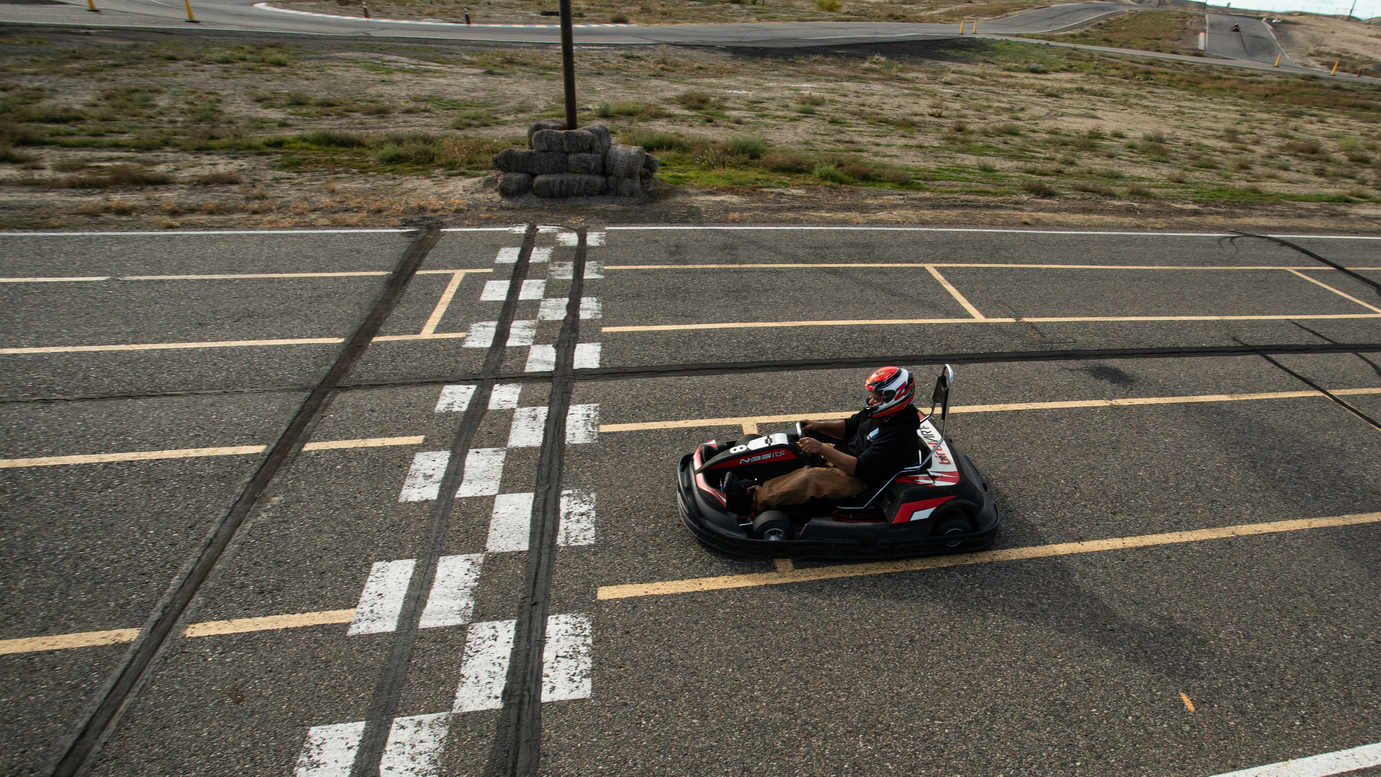 a person riding a go - cart in a parking lot