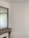 An elegant interior space featuring intricate wall moulding and a large mirror above a stone fireplace. The walls are light-colored with detailed decorative trim along the ceiling. A curtain filters natural light from a window partially visible in the mirror.