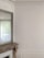 An elegant interior space featuring intricate wall moulding and a large mirror above a stone fireplace. The walls are light-colored with detailed decorative trim along the ceiling. A curtain filters natural light from a window partially visible in the mirror.