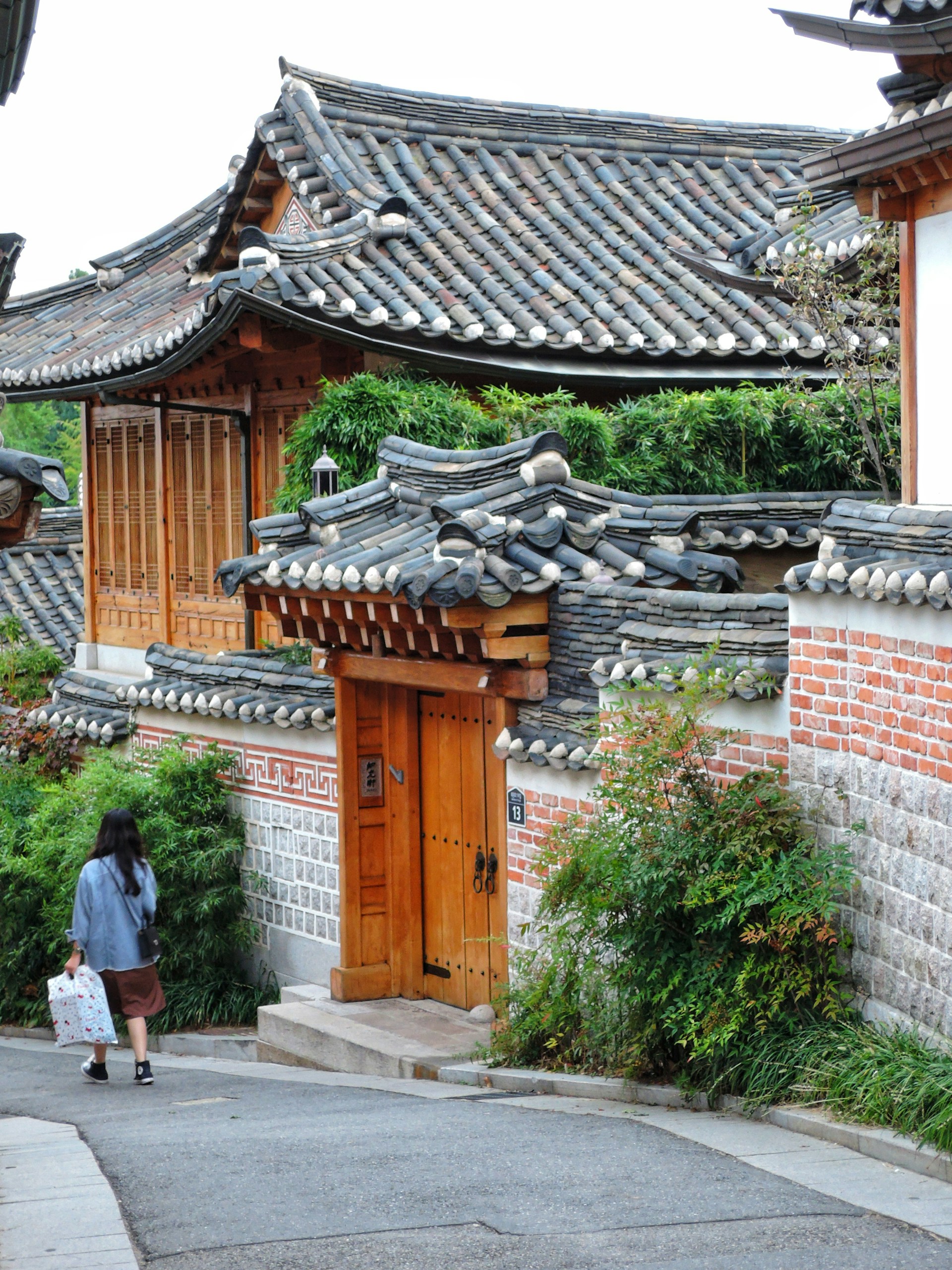 a woman walking down a street past a building