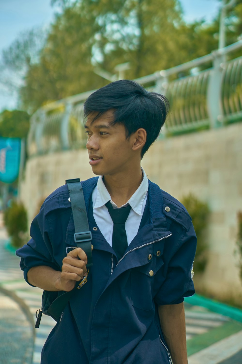 a man in a blue jacket and tie holding a camera