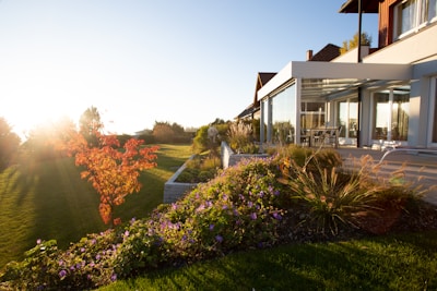 a house with a large lawn and flowers in front of it