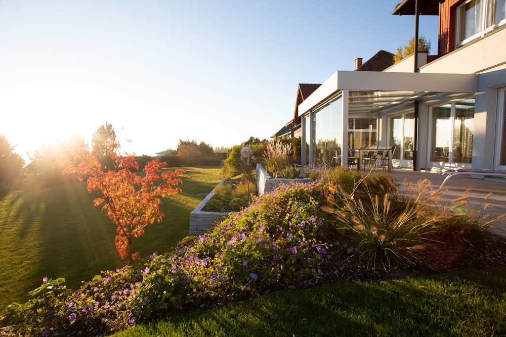 a house with a large lawn and flowers in front of it