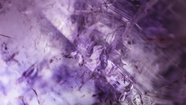 Close-up of a geopolimeric pot showing its violet iron oxide texture with sparkling mica highlights under soft light.