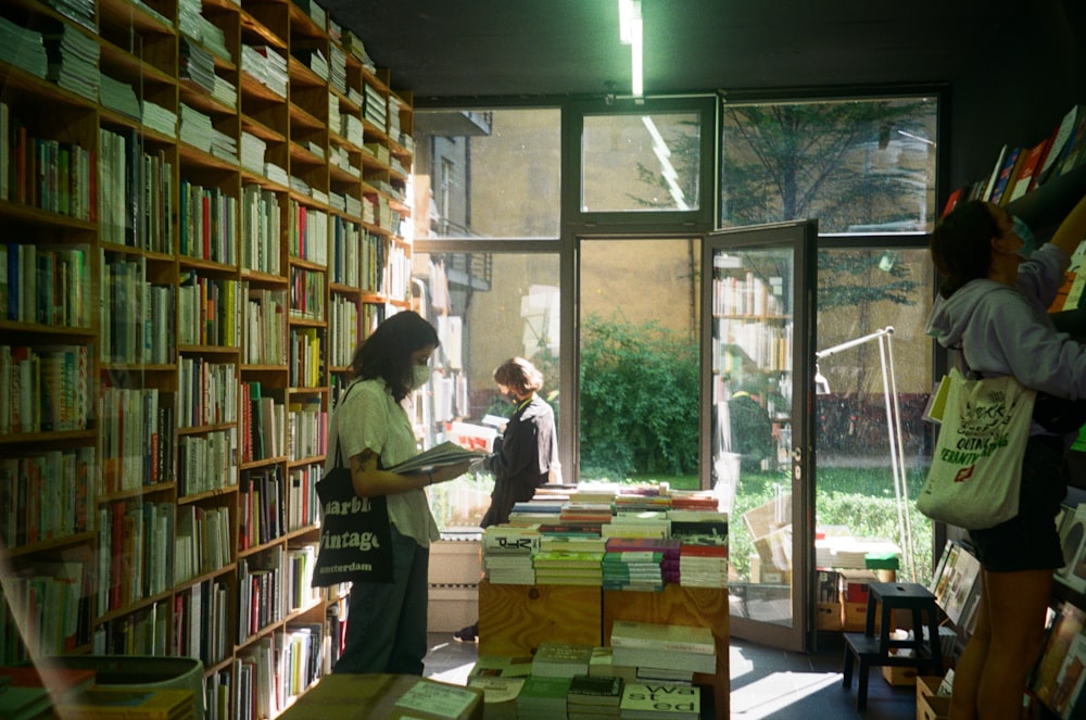 a woman standing in front of a bookshelf filled with books