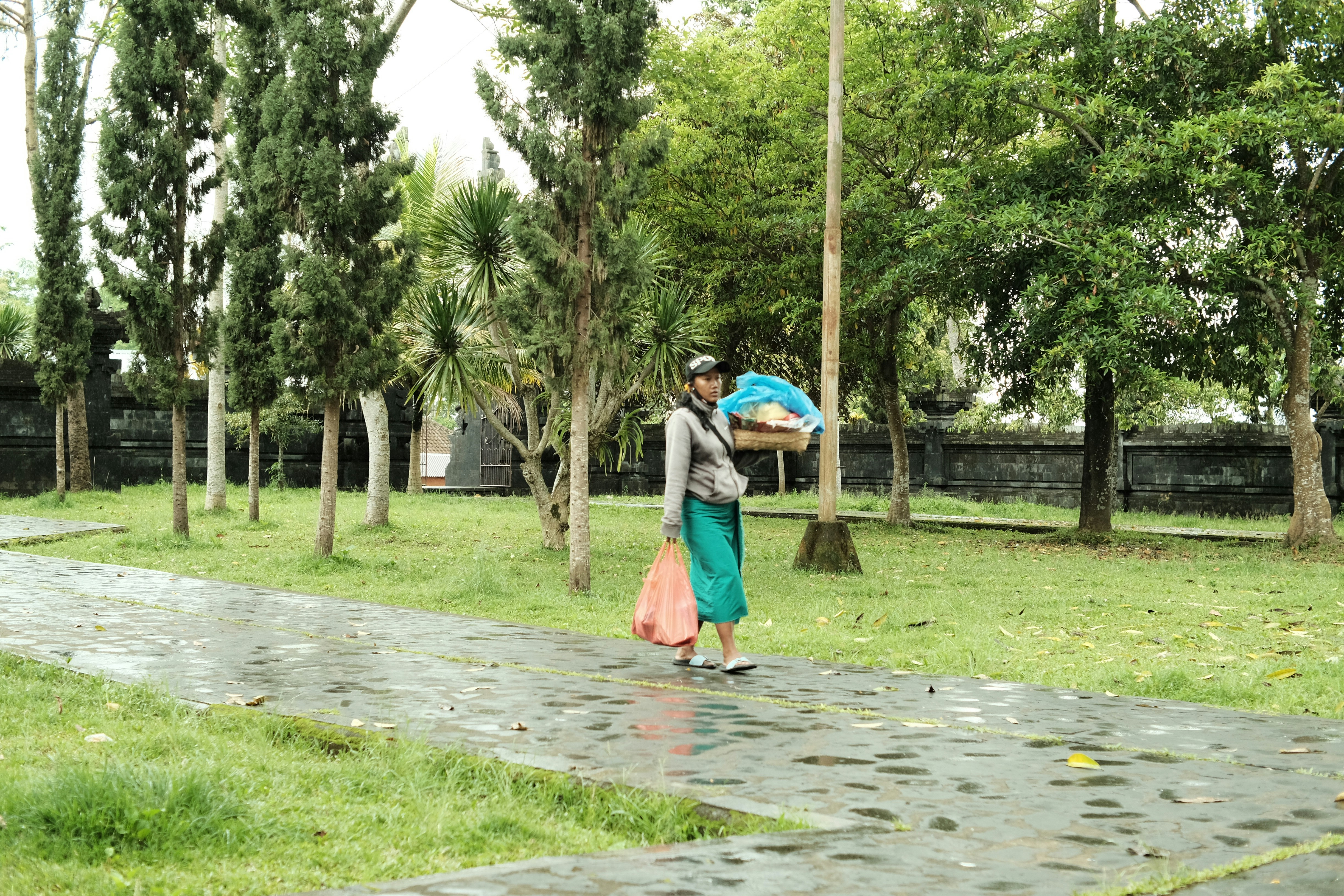 a woman walking down a sidewalk carrying an umbrella