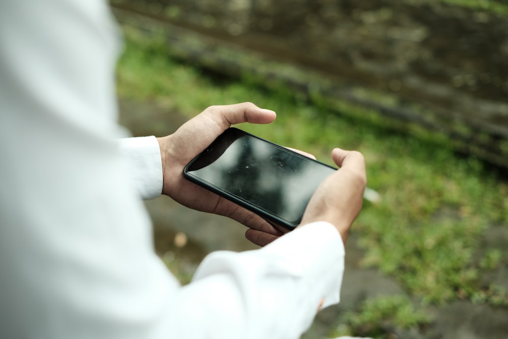 a person holding a cell phone in their hand