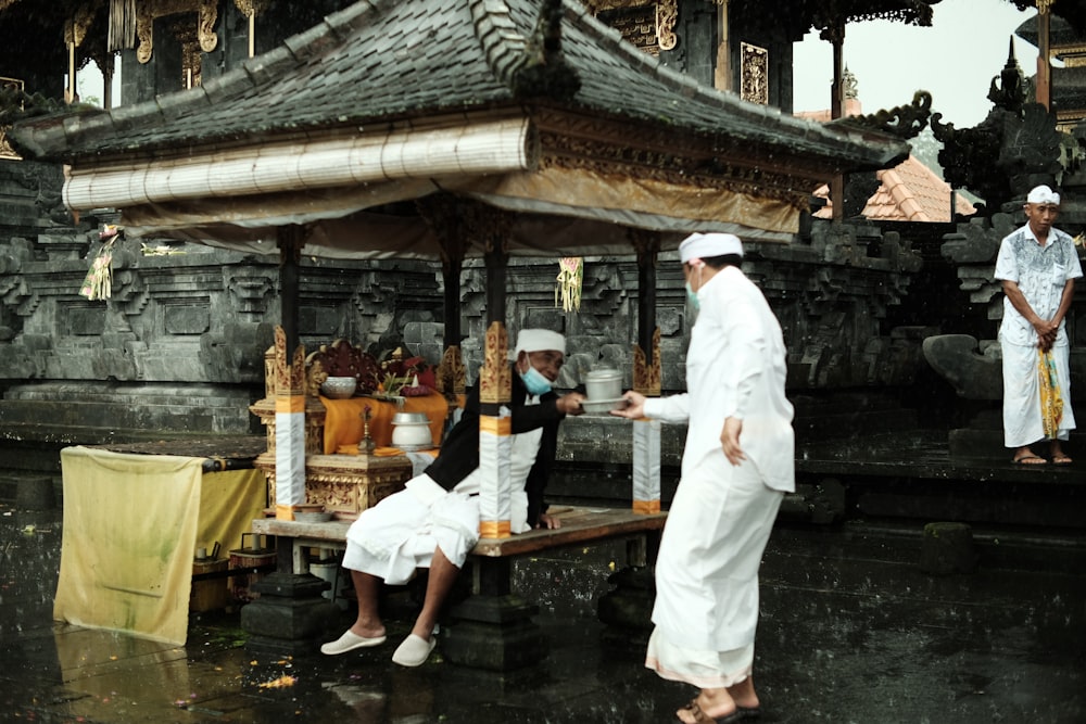 a group of men standing around a wooden structure