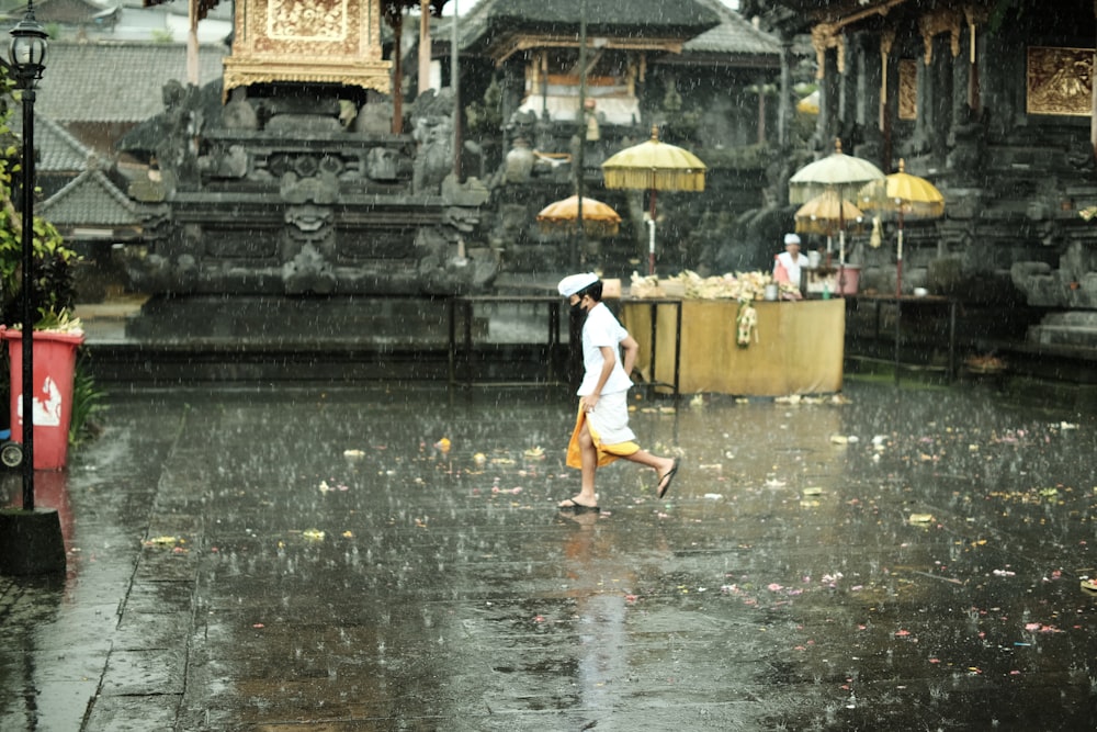 Una persona che cammina sotto la pioggia con un ombrello