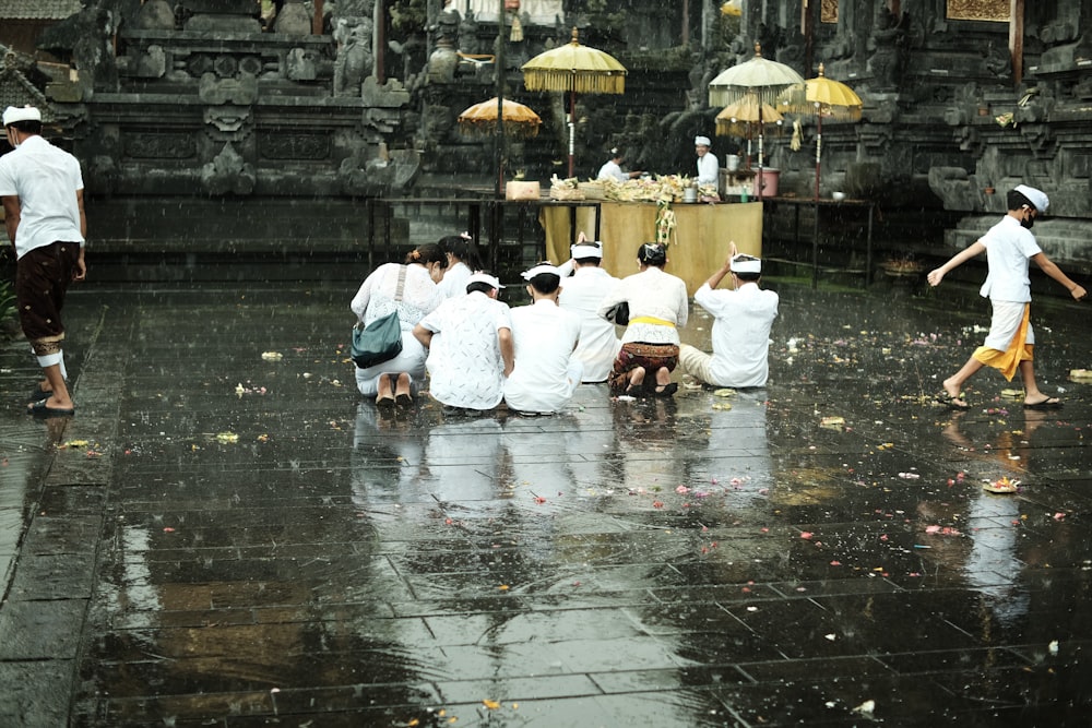 a group of people standing on top of a wet ground