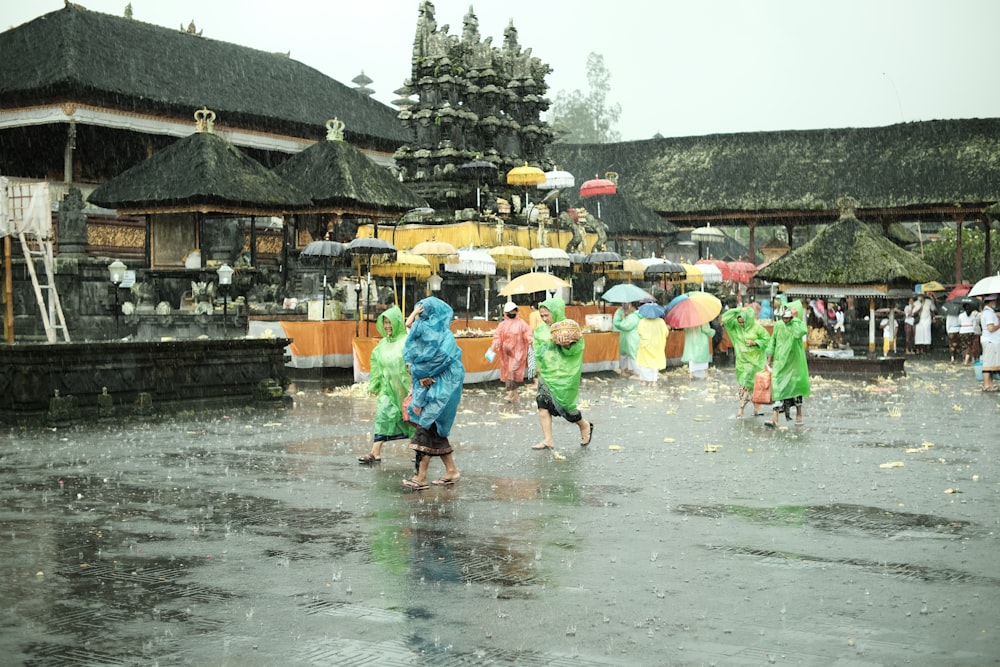 a group of people walking in the rain with umbrellas