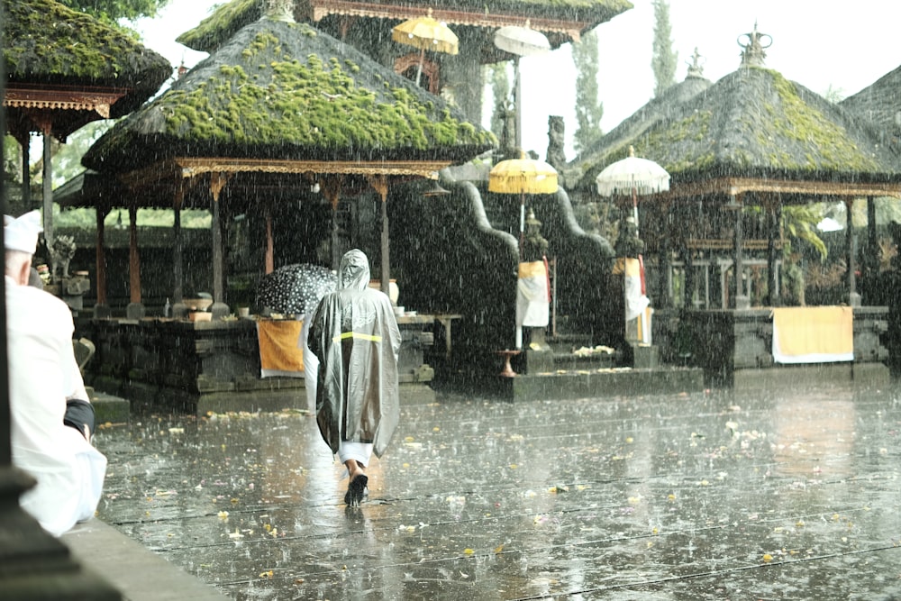Ein Mann geht mit Regenschirm im Regen spazieren