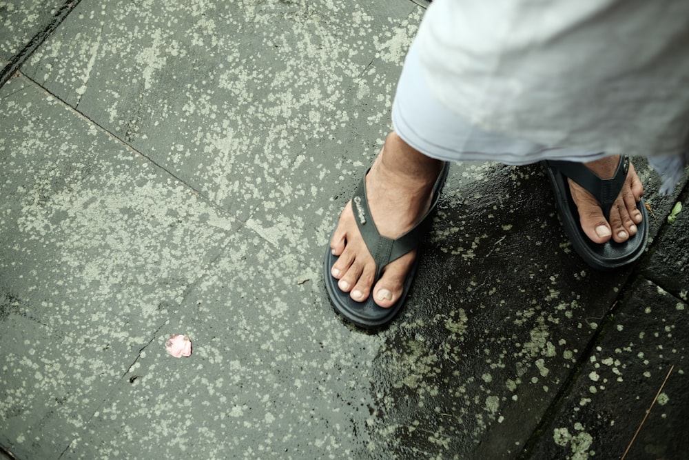a person standing on a sidewalk wearing sandals