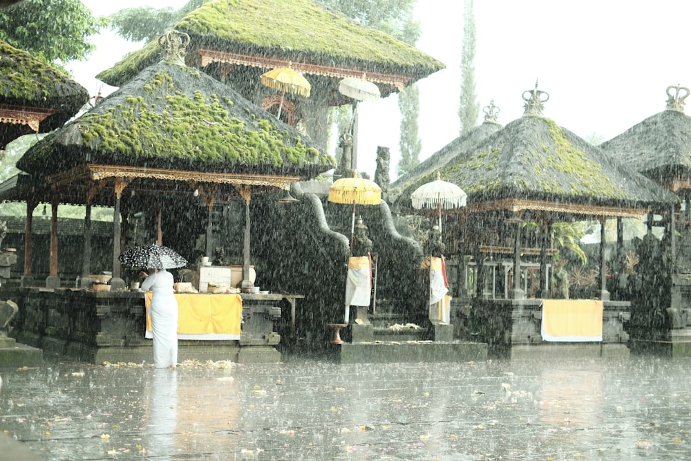 Eine Person, die mit einem Regenschirm im Regen steht