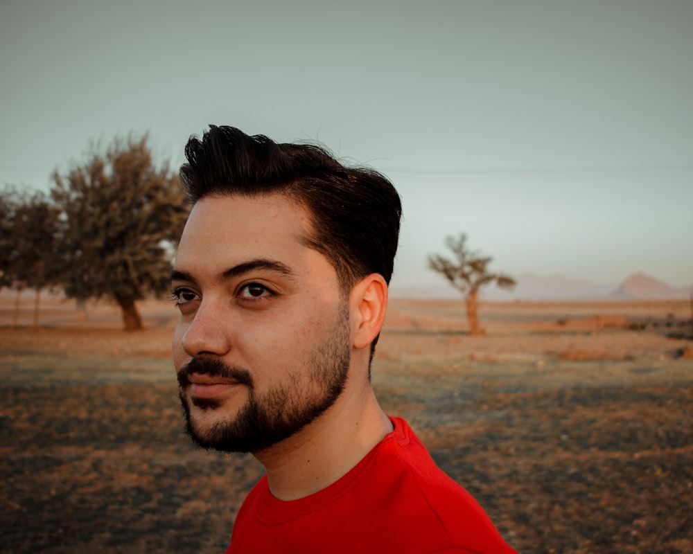 a man in a red shirt standing in a field