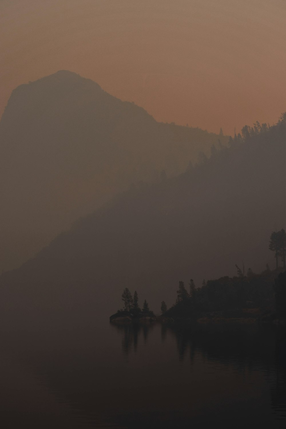 a boat floating on top of a lake next to a mountain